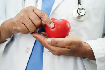 Asian doctor holding red heart in hospital, cardiovascular disease, CVD.