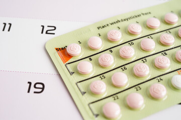 Birth control pills on calendar, contraception health and medicine.