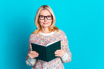 Portrait of pretty aged lady hold book empty space wear sweater isolated on turquoise color background