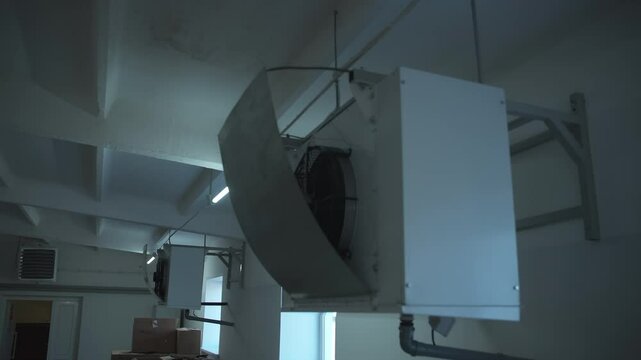 Close-up of a ventilation system working inside the poultry farm plant room. Ventilation fan controlling the air in the farm room. Huge Ventilation fans attached to the wall of a farm room.