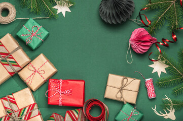 Boxing Day concept. Frame, background with fir branches and paper gift boxes, wrapping ribbons and Christmas tree toys. DIY gifts, copy space.