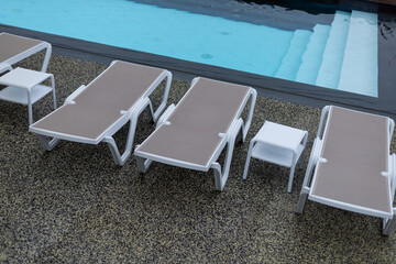 white plastic sunbeds by the pool