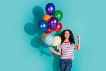 Fototapeta premium Photo portrait of pretty young girl hold air balloons winning wear trendy striped outfit isolated on cyan color background