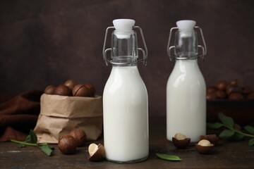 Bottles of macadamia milk and nuts on wooden table