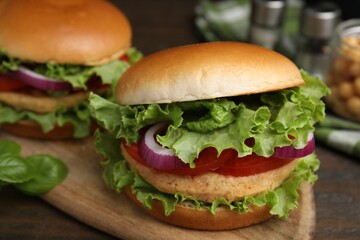 Delicious vegetarian burgers with chickpea cutlets on wooden table, closeup