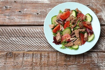 Delicious fresh tuna salad on wooden table, top view. Space for text