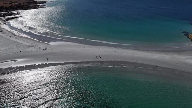 Tourists walking across sandbar of Diamond Island towards beach, aerial tilting shot