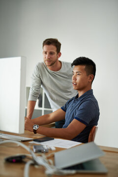 Team, business men and help on computer for training, creative or design on post production software. Tech, coaching or mentor teaching intern for video editing project, advice or feedback in startup