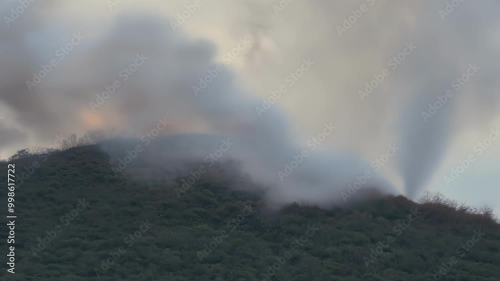 Poster helicopter battles a wildfire, sending smoke into the air and threatening nature below. the blaze hi