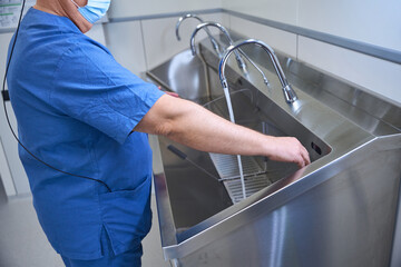 Surgeon performs hand sanitizing routine before surgery
