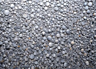 Obraz premium a close-up view textured surface composed of numerous small, round, metallic objects in various shades of gray, creating a visually striking pattern