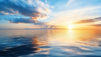 Obraz premium Stunning sunset over the ocean with dramatic clouds and golden light reflecting on the water.
