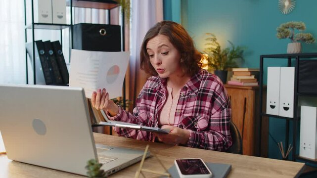 Businesswoman working on laptop at office desk talking online communication video call with employee, boss shows graphical analytics. Girl freelancer support services looking at webcam of computer