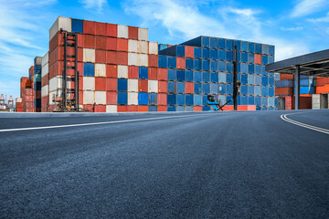 Stacked containers and empty asphalt road at the port