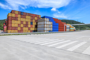 Stacked containers and empty asphalt road at the port