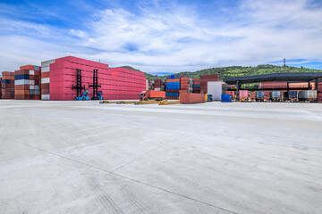 Stacked containers and empty asphalt road at the port