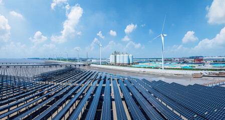 solar panels with wind turbines and factory by the sea © zhao dongfang
