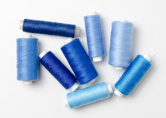 Blue thread spools on white background.