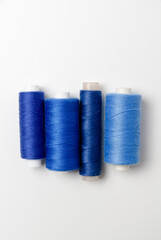 Blue thread spools on white background.