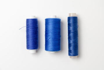 Blue thread spools on white background.