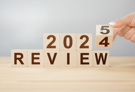 Review 2025. hand flips wooden cube and changes words REVIEW 2024 to REVIEW 2025. Business 2025 review new year concept. Economy and business. Phrase 2025 review on wooden table