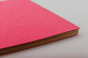 Bright magenta colour craft paper photo album with spiral binding on a white studio background. DIY scrapbooking, storing printed photos. Multiple angles of eco-friendly designed notebook