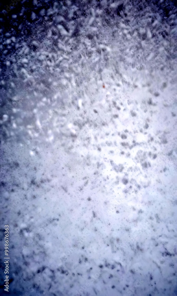 Poster a close-up view snow-covered surface, with a textured and slightly blurred appearance, conveying a s
