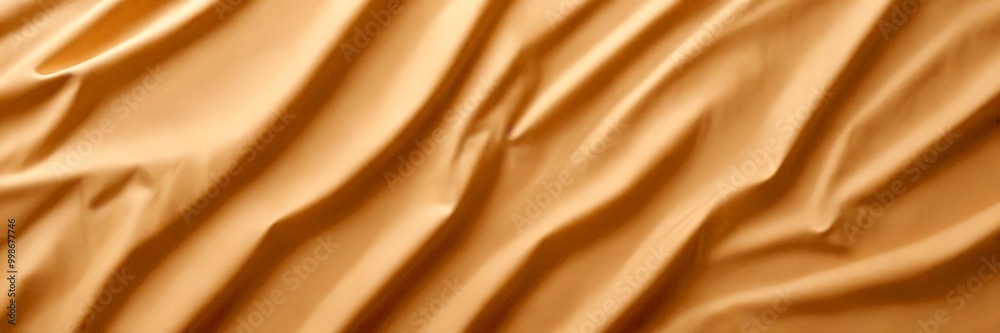 Poster a close-up view crumpled, beige-colored fabric, with the folds and creases creating a textured and dynamic appearance