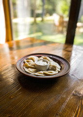 Dumplings in authentic Ukrainian dishes on a wooden table. Concept of Ukrainian cuisine