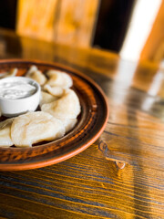 Dumplings in authentic Ukrainian dishes on a wooden table. Concept of Ukrainian cuisine