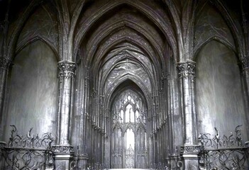 Fototapeta premium the interior Gothic cathedral, featuring a grand, dark stone archway with intricate carvings and a central archway with a stained glass window