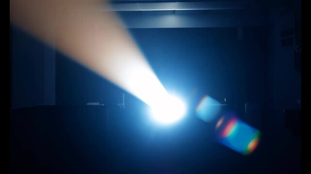 A bright projector beam cuts through darkness, creating dramatic reflections and an engaging visual atmosphere.