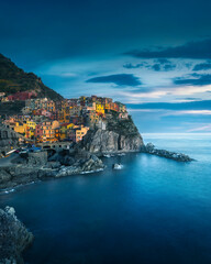 Fototapeta premium Manarola village, rocks and sea in blue hour. Cinque Terre, Italy.