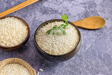 White Rice Bowl with Parsley Sprig on Rustic Background.