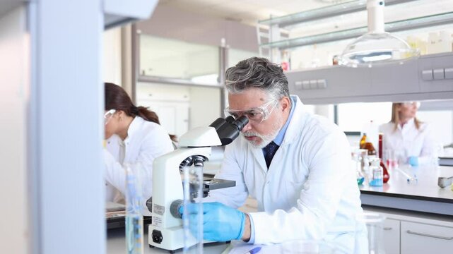 Mature lab specialist examining something on the microscope