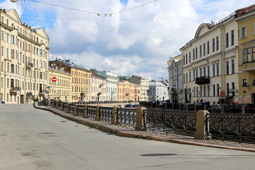 Obraz premium A picturesque street view along an embankment with historic buildings in a European city. The calm atmosphere and traditional architecture create a serene urban landscape.