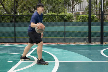 A man plays basketball while sitting on the court.