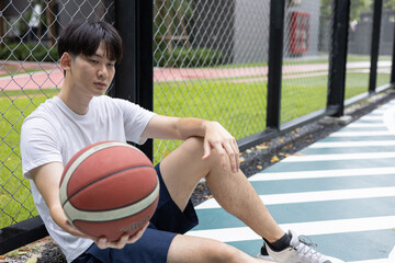 Young Man Resting on Basketball Court