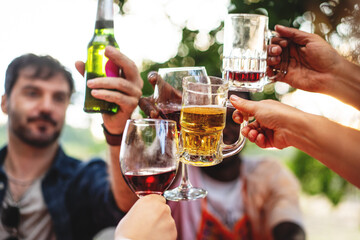 Diverse friends toasting with various drinks, outdoor social gathering celebration