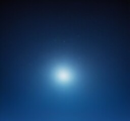 Obraz premium A bright, white star shines against a deep blue night sky, surrounded by a few small, distant stars