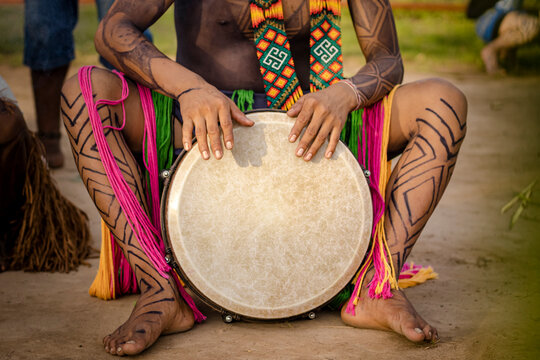 Sao Paulo, SP, Brazil - April 16 2023: Indigenous people with body paint and traditional accessories from the Huni Kuin culture playing djemb&ecirc;.