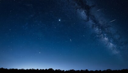 Fototapeta premium A night sky with a starry backdrop, a few shooting stars, and a faint Milky Way galaxy visible in the distance