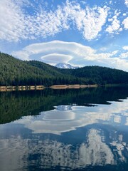 Vertical image of lenticular clouds over Mount Shasta reflected in Lake Siskiyou