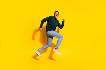 Full body photo of nice young male running hurry shopping sales wear trendy green outfit isolated on yellow color background