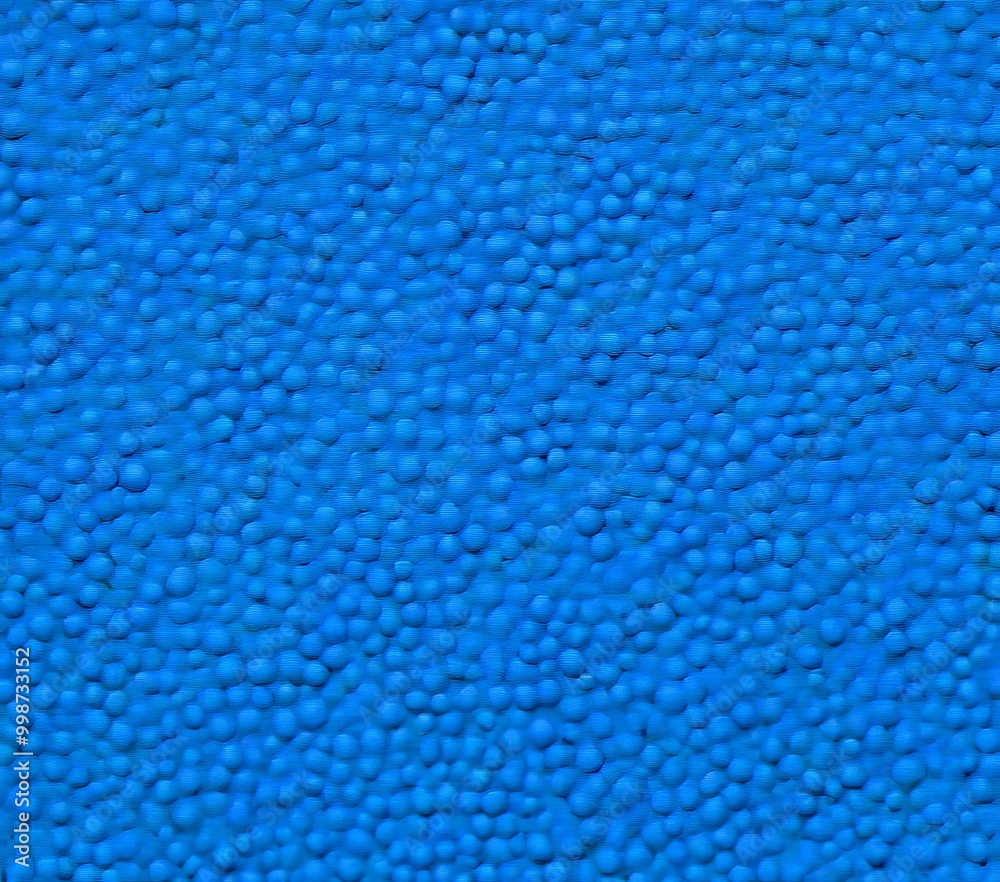 Aufkleber a close-up view textured surface with a blue color, resembling a carpet or a fabric The surface is composed of small, round, and irregularly shaped objects that create