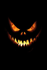 Fototapeta premium Halloween pumpkin with spooky glowing face