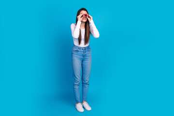 Full size photo of pretty teen girl spying watch binoculars wear trendy white outfit isolated on...