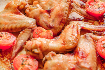 fried chicken wings with tomatoes, selective focus