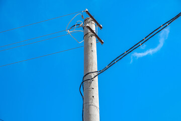 electric pole with lines and wires against blue sky.