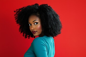 Confident Black woman with natural afro hairstyle in teal blue attire looking over her shoulder against a vibrant red background exuding cool and stylish vibes for diverse usage.